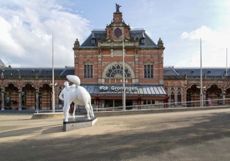 Groningen, The Netherlands - 2020: Building of the central station with statue in front